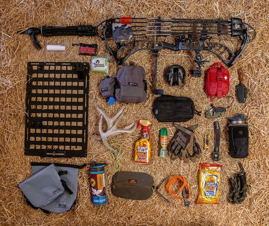 Hunting gear scattered across the ground, showing how all the equipment can be organized and stored on one Gear Anchor MOLLE panel.